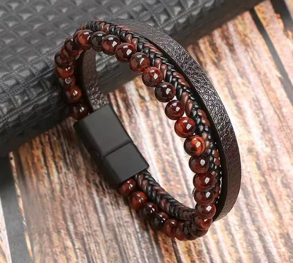 Bracelet with red beads and leather strap on a wooden surface
