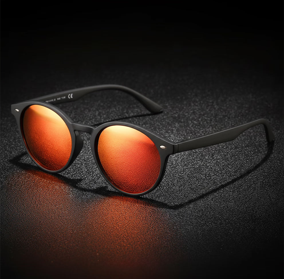 Sunglasses with orange lenses and black frames on a dark textured surface