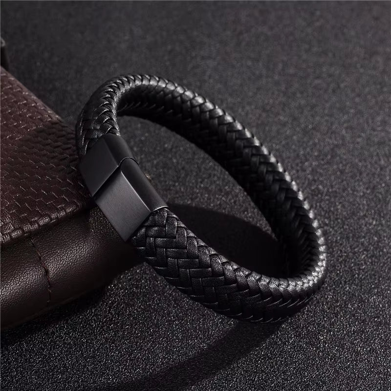 Black braided leather bracelet on a dark textured surface