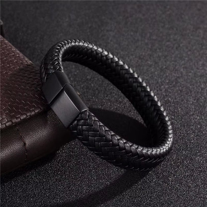 Black braided leather bracelet on a dark textured surface