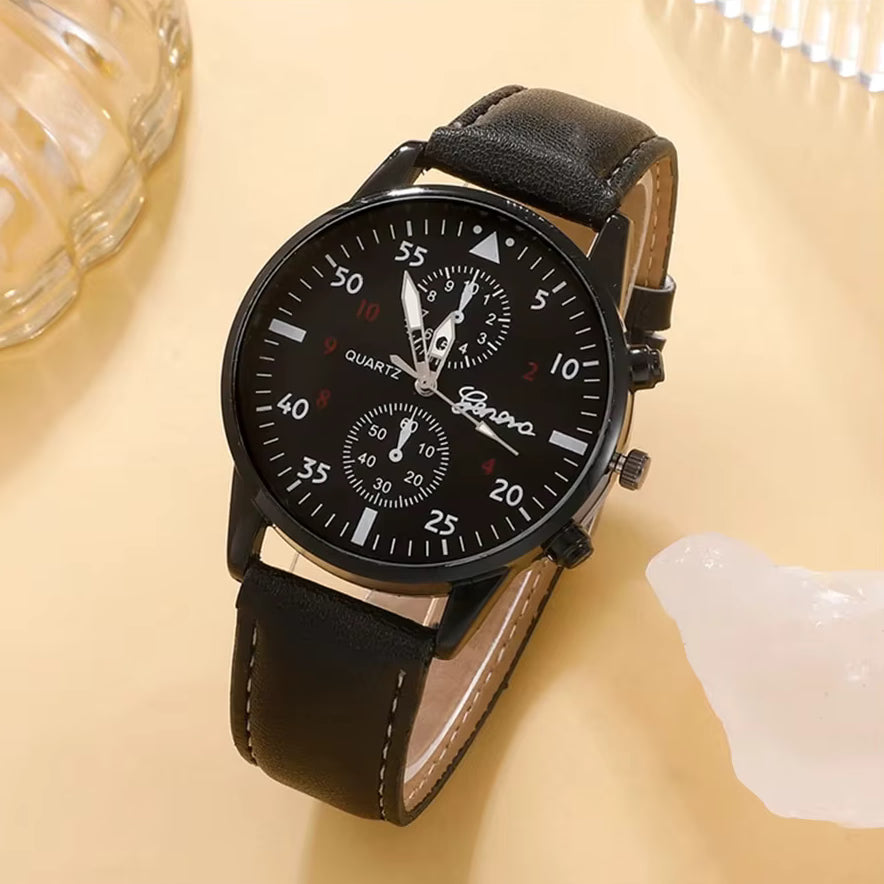 Black wristwatch with leather strap on a beige surface