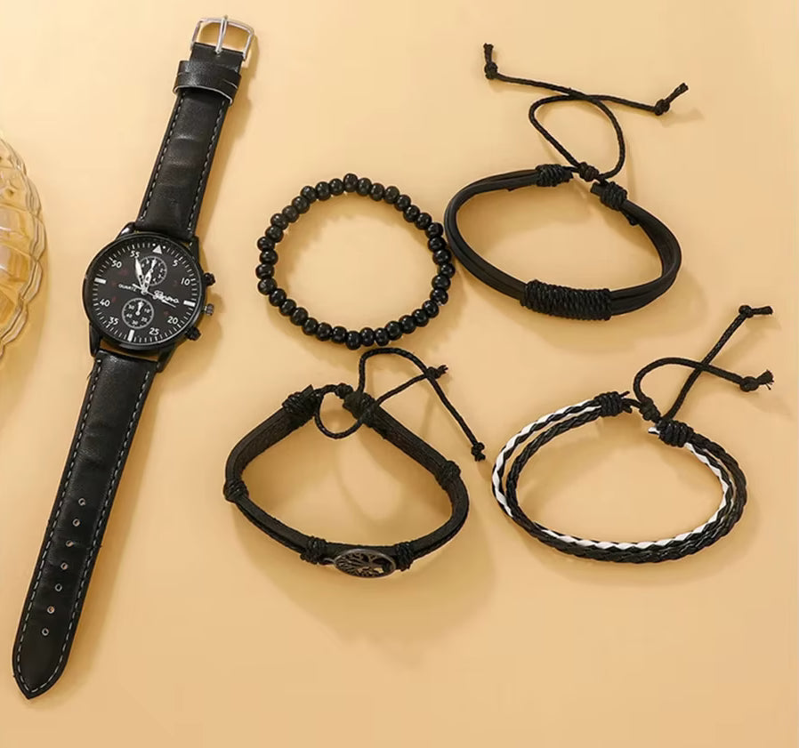 Black watch with leather strap and black braided bracelets on a beige background