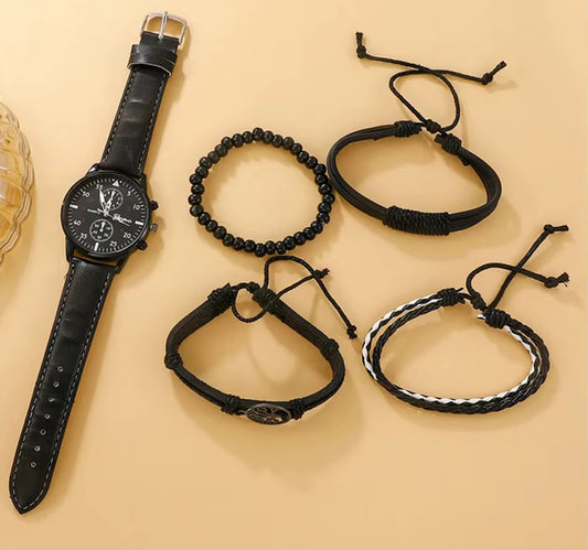 Black watch with leather strap and black braided bracelets on a beige background