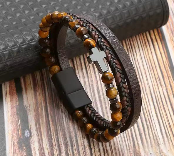 Bracelet with cross and wooden beads and leather strap on a wooden surface