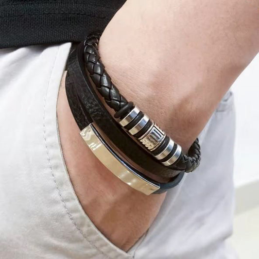 Close-up of a wrist wearing multiple leather and metal bracelets.