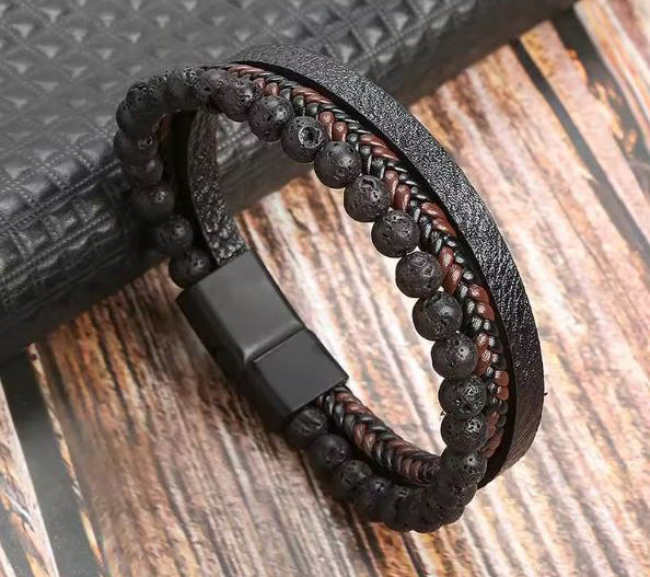 Black beaded bracelet with leather strap on a wooden surface