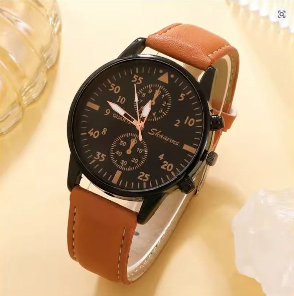 Wristwatch with brown leather strap and black dial on a light yellow background