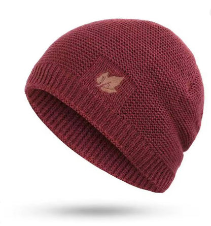 Burgundy knit beanie with a small logo on a white background