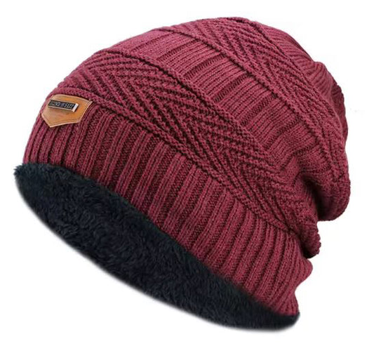 Burgundy knit beanie with black cuff on a white background
