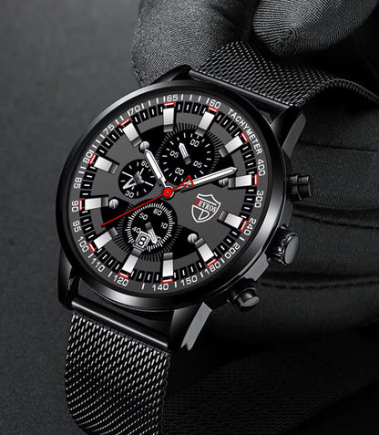 Black wristwatch with detailed face held by a gloved hand on a dark background