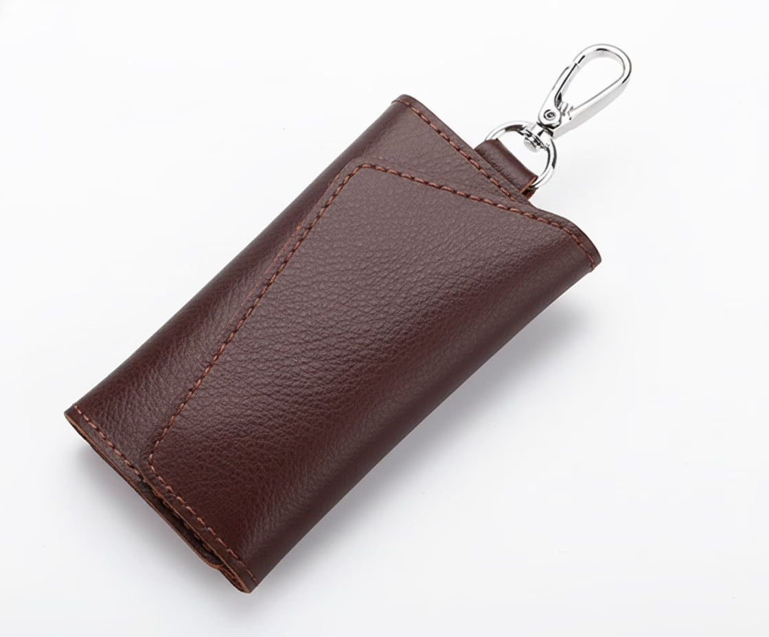 Brown leather key case with a silver clip on a white background