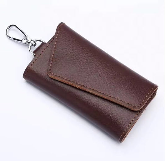 Brown leather key holder with a silver clip on a white background