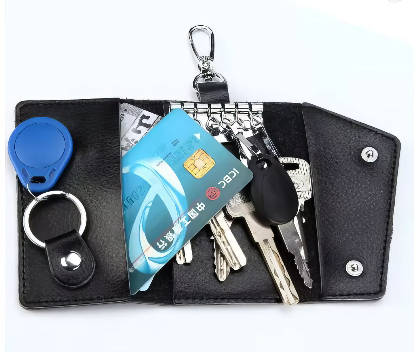 Black keychain organizer with keys, cards, and a tracker on a white background