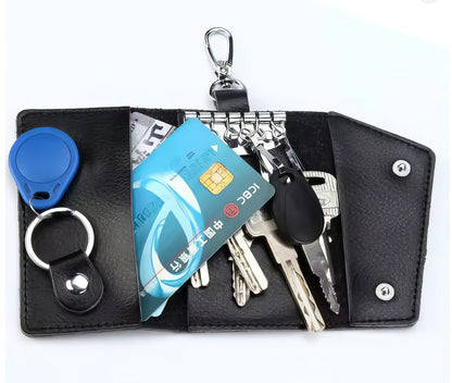 Black keychain organizer with keys, cards, and a tracker on a white background