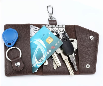 Brown leather key organizer with keys, cards, and a blue fob on a white background