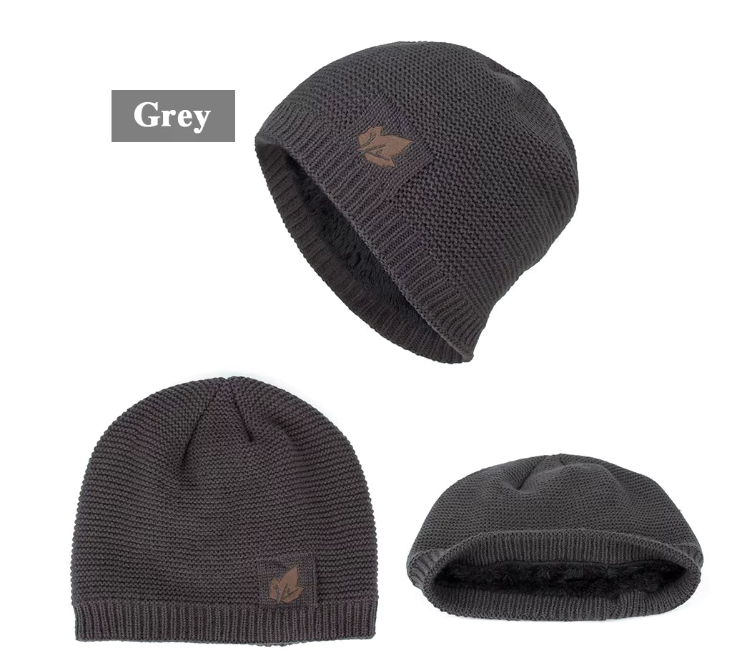 Three views of a grey knit beanie with a logo on a white background