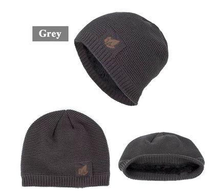 Three views of a grey knit beanie with a logo on a white background