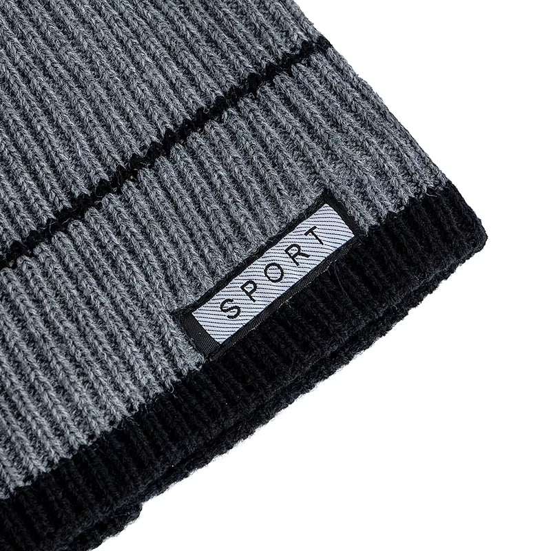 Grey and black knit beanie with a brand label on a white background