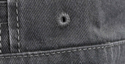 Close-up of a bullet hole on grey denim fabric