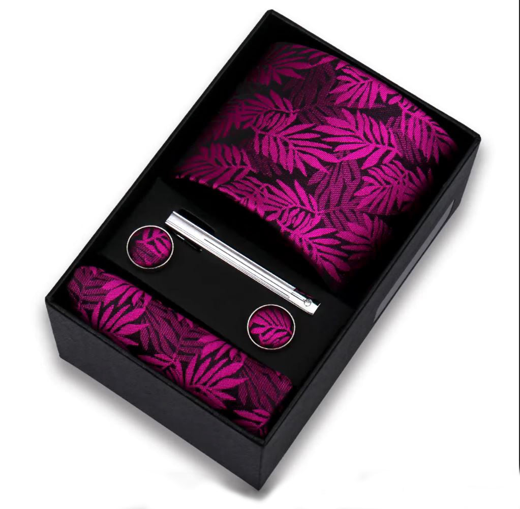 Leaf patterned tie, pocket square, tie clip and cufflinks set in a black box on a white background