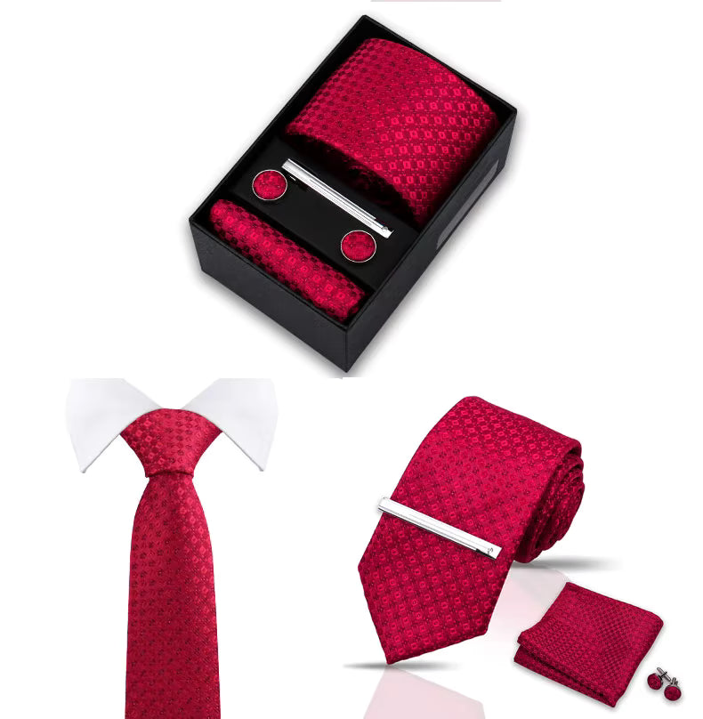 Red patterned tie set with tie clip, pocket square, and cufflinks in a black box on a white background.