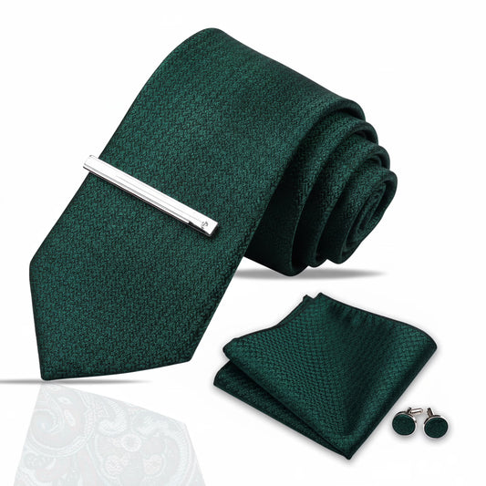 Green tie with silver tie clip, green pocket square, and green cufflinks on a white background