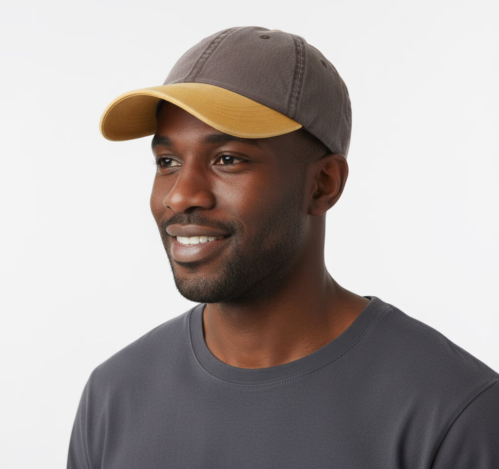 Man wearing a two-tone cap and grey shirt on a white background