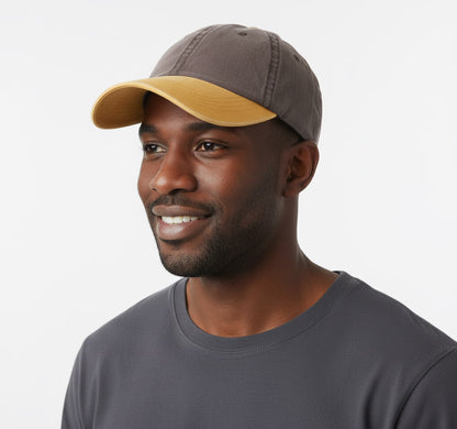 Man wearing a two-tone cap and grey shirt on a white background
